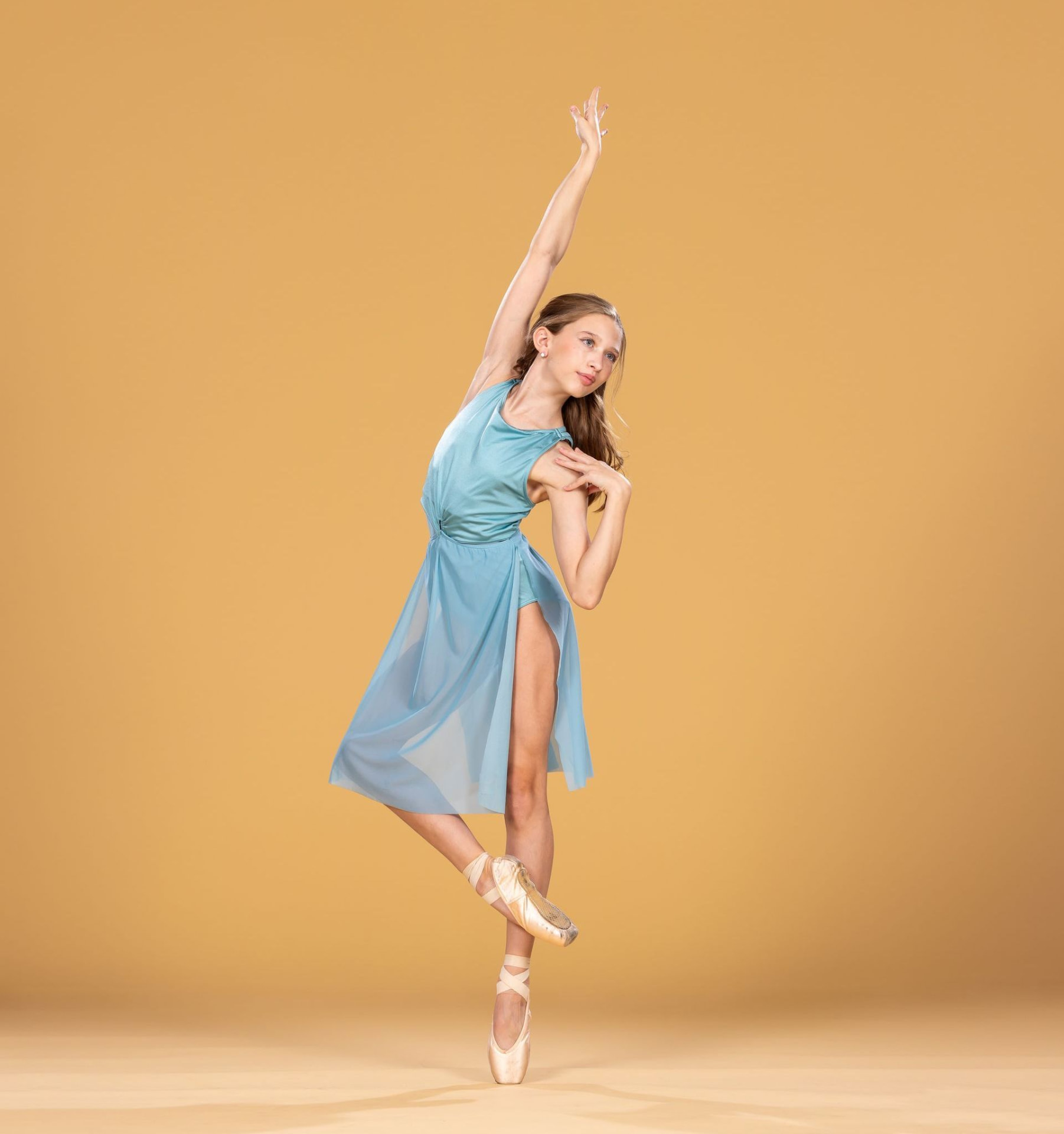 Ballet dancer in a blue dress on a gold background